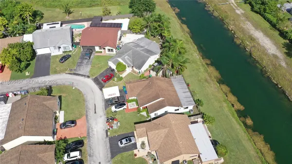 an aerial view of a house with swimming pool and a yard