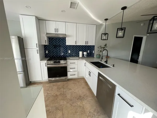 a kitchen with a refrigerator and a sink