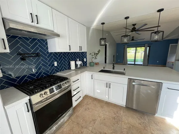 a kitchen with granite countertop a sink stainless steel appliances and cabinets