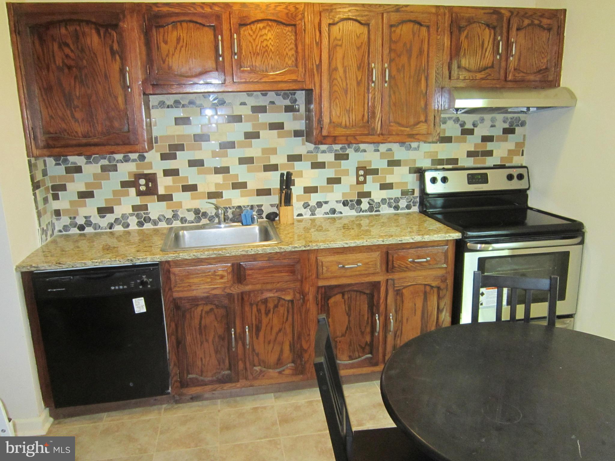 8587 Tyrolean Way Springfield, VA 22153 - Photo 20 of 30 a kitchen with stainless steel appliances granite countertop a stove a sink and a microwave