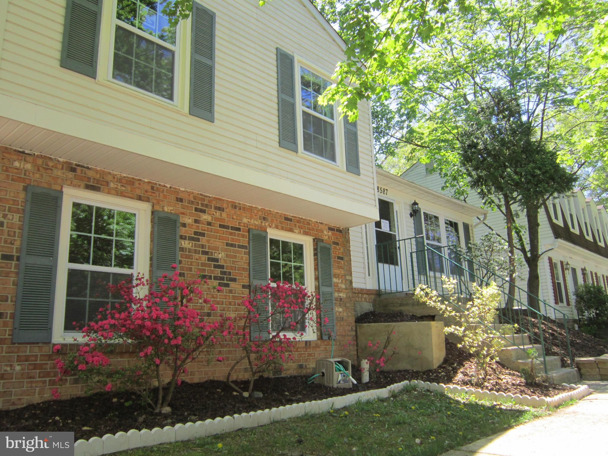 8587 Tyrolean Way Springfield, VA 22153 - Photo 3 of 30 a view of a house with brick walls and a flower garden