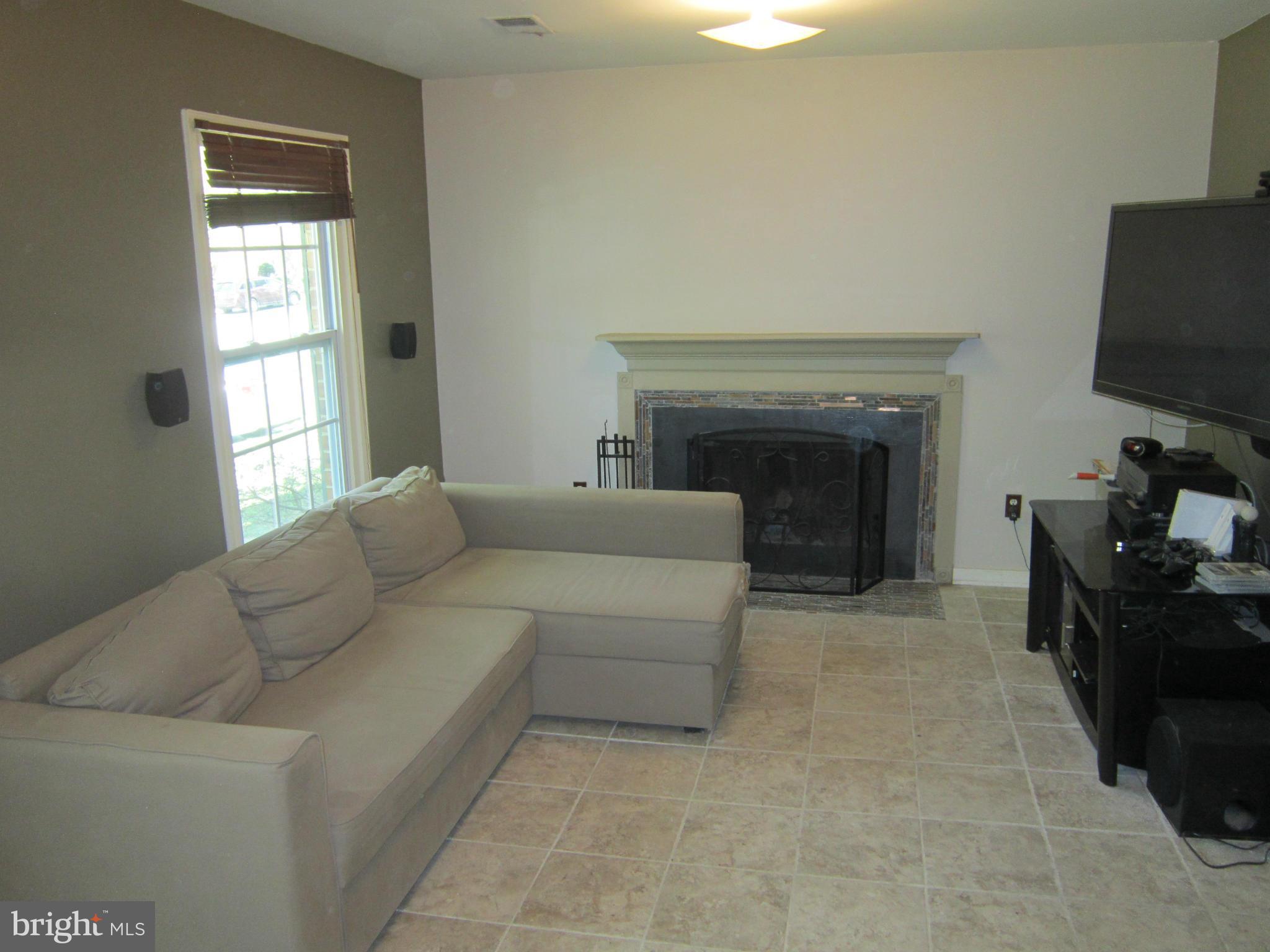 8587 Tyrolean Way Springfield, VA 22153 - Photo 22 of 30 a living room with furniture and a fireplace