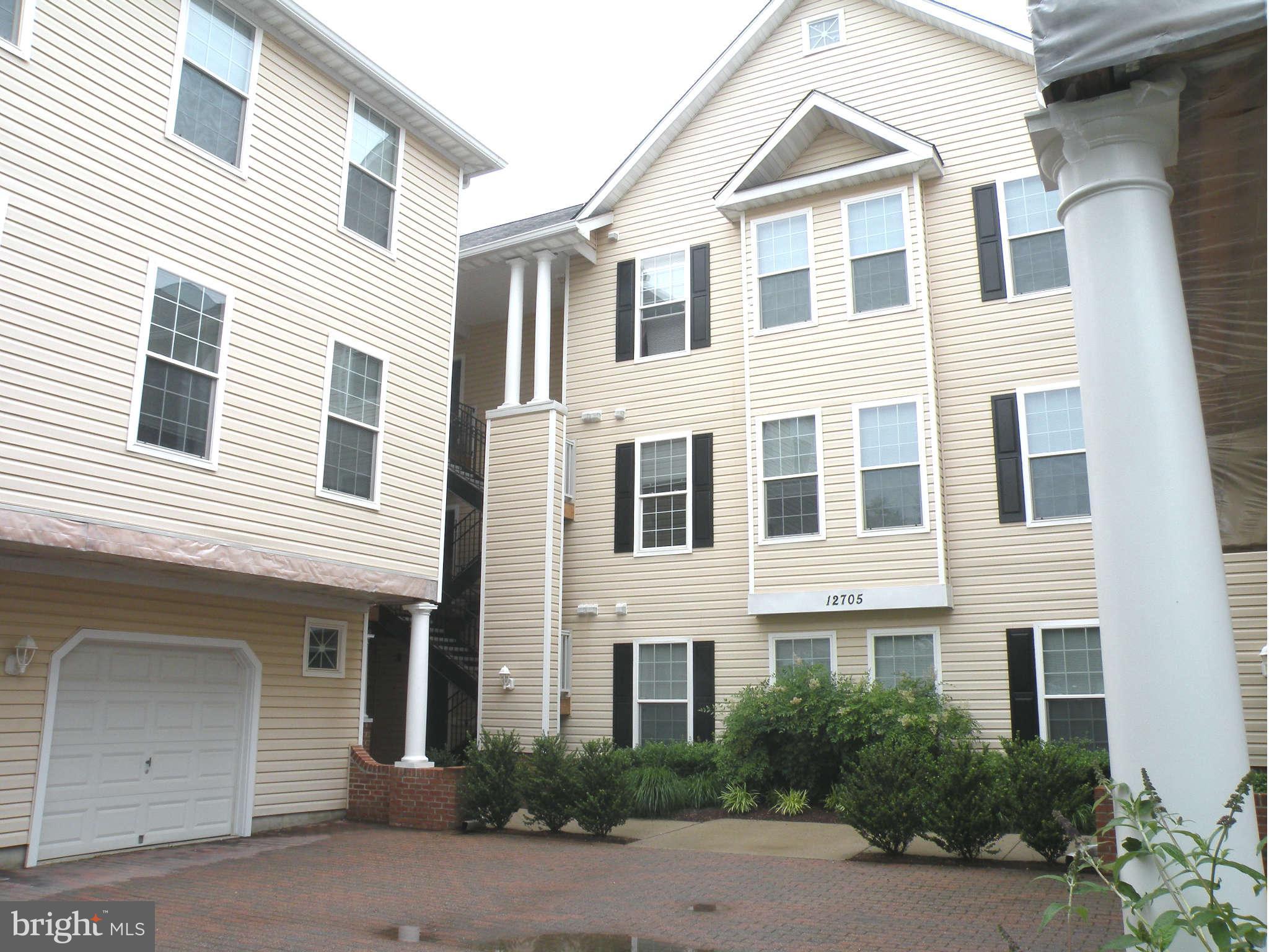 12705 Found Stone Road, Unit 301 Germantown, MD 20876 - Photo 1 of 21 a front view of a house with a yard and garage