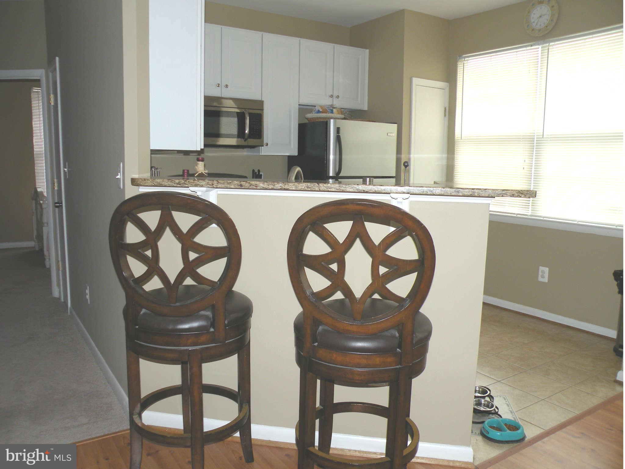 12705 Found Stone Road, Unit 301 Germantown, MD 20876 - Photo 11 of 21 a kitchen with stainless steel appliances a table and chairs in it