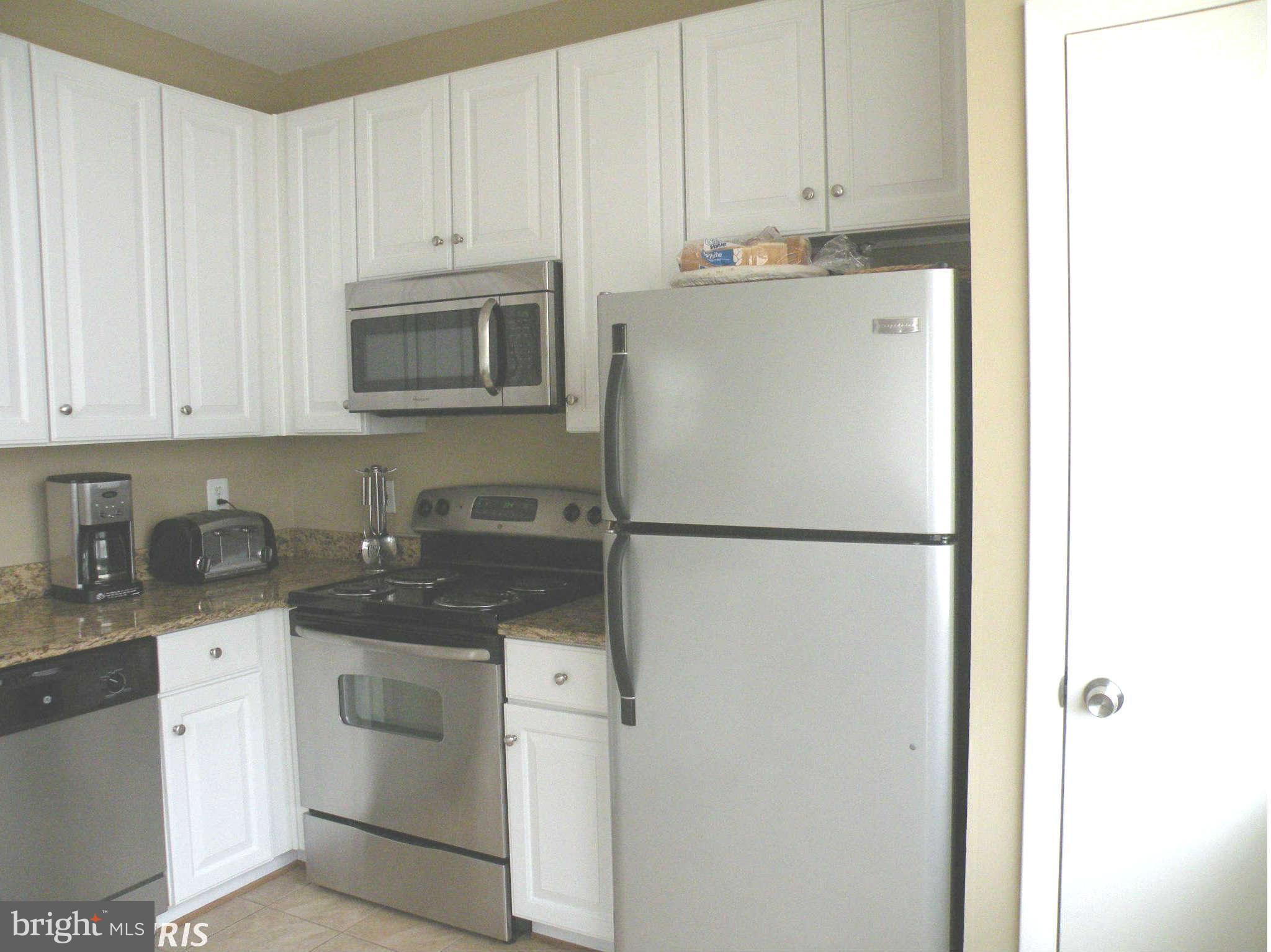 12705 Found Stone Road, Unit 301 Germantown, MD 20876 - Photo 13 of 21 a kitchen with stainless steel appliances granite countertop a refrigerator sink and cabinets