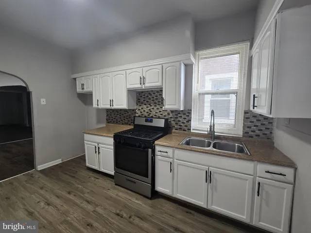 a kitchen with granite countertop a sink stainless steel appliances and cabinets