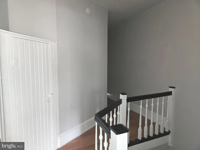 a view of a hallway with wooden floor and entryway