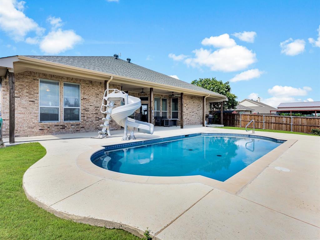 205 King George Road Ponder, TX 76259 - Photo 32 of 37 Brick exterior with an in-ground swimming pool, concrete surround, and a covered patio area