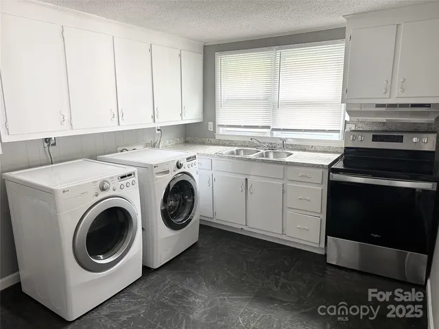 a utility room with sink dryer and washer