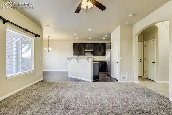 a kitchen with kitchen island granite countertop a sink wooden cabinets and stainless steel appliances