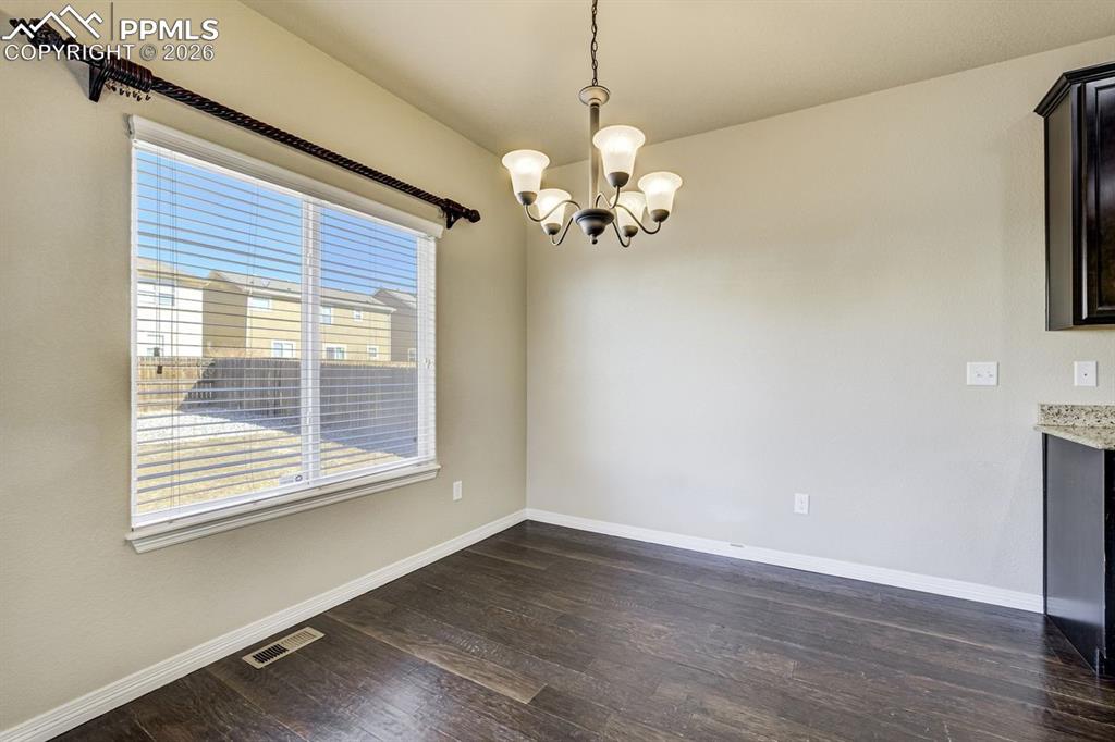 Undisclosed Address Colorado Springs, CO 80925 - Photo 17 of 45 a view of a room with wooden floor and chandelier