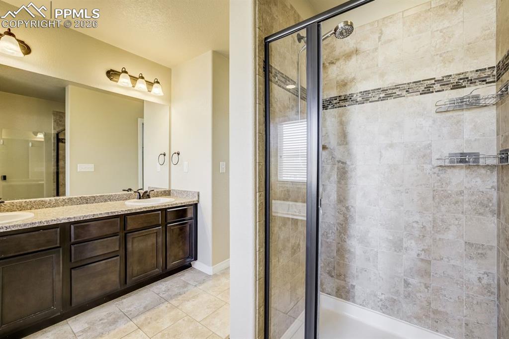 Undisclosed Address Colorado Springs, CO 80925 - Photo 28 of 45 a bathroom with a double vanity sink mirror and shower