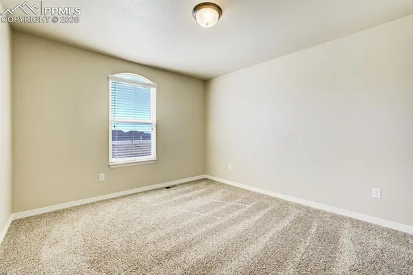 an empty room with closet and a window