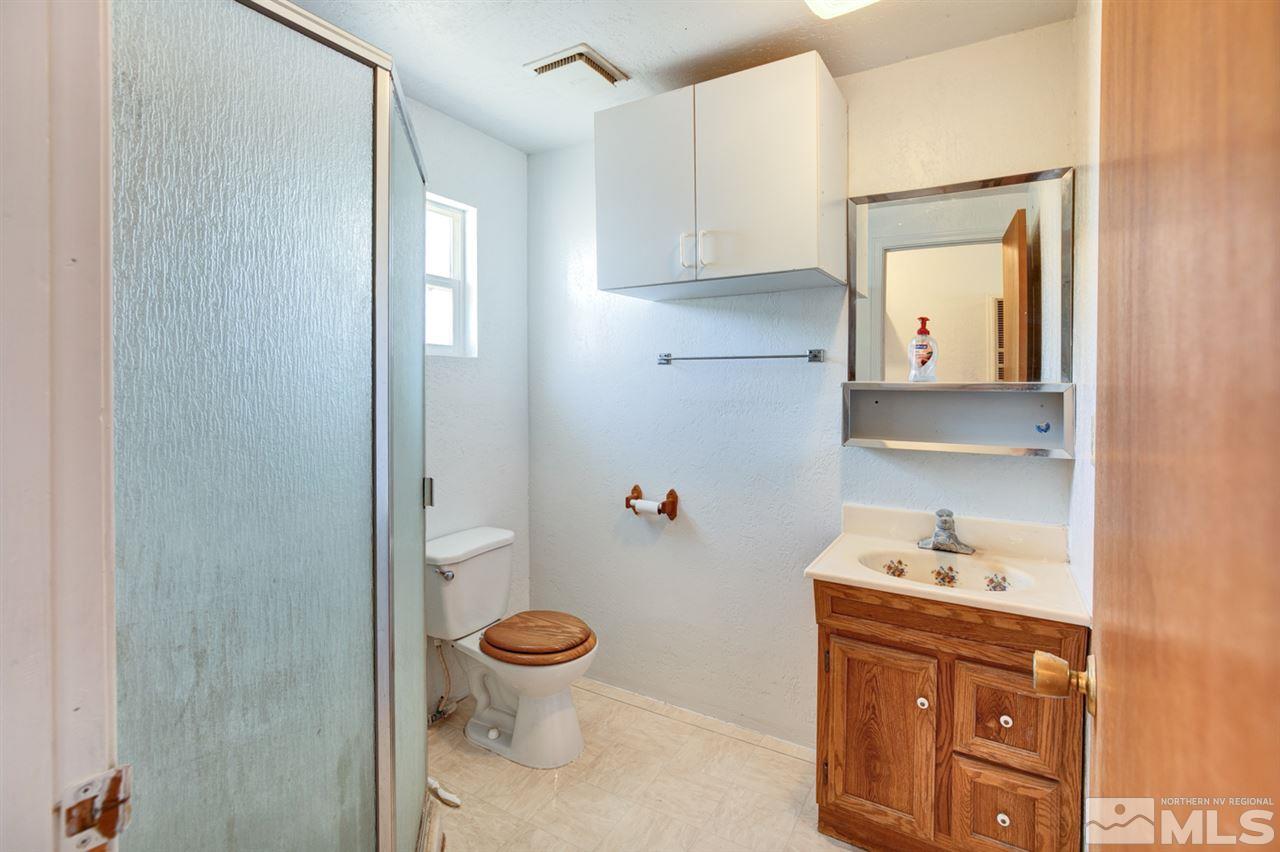 4320 Reno Highway Fallon, NV 89406 - Photo 13 of 28 a bathroom with a toilet sink and mirror