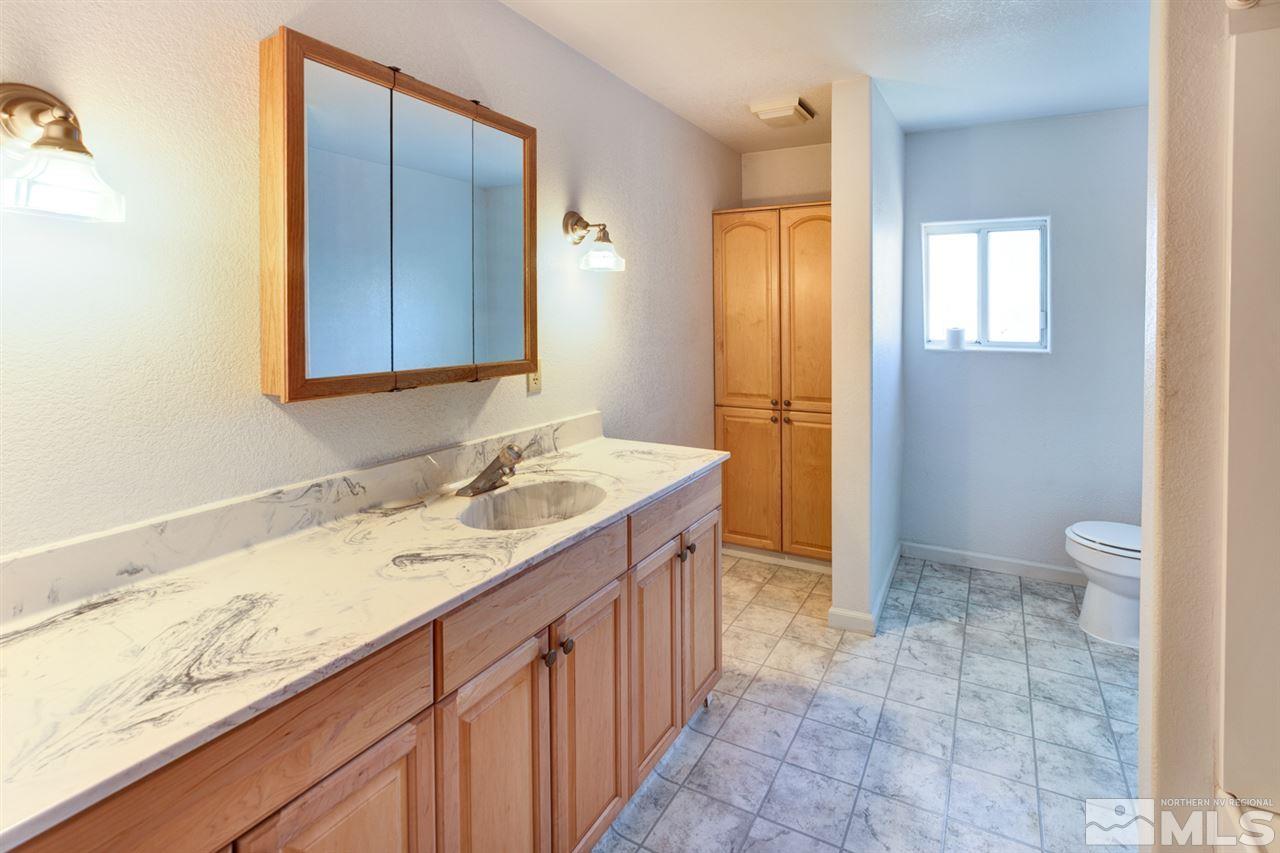 4320 Reno Highway Fallon, NV 89406 - Photo 16 of 28 a bathroom with a granite countertop sink toilet and shower