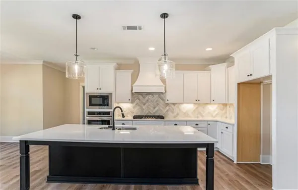 a kitchen with kitchen island a sink appliances and wooden floor