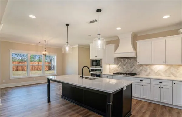 a kitchen with a sink stove and wooden floor