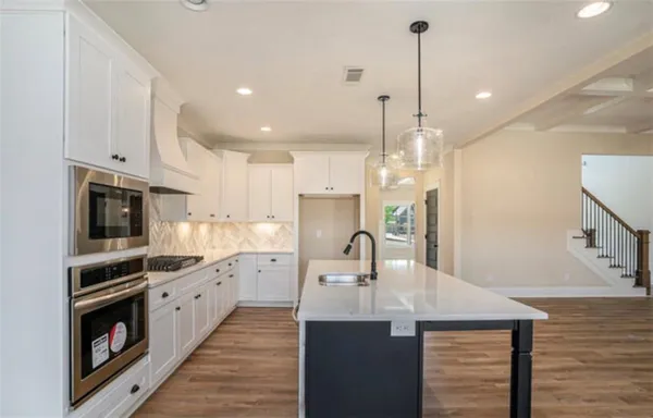 a kitchen with kitchen island a sink stainless steel appliances and cabinets
