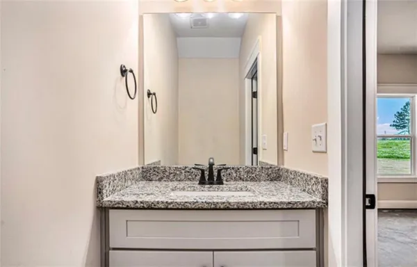 a bathroom with a granite countertop sink and a mirror