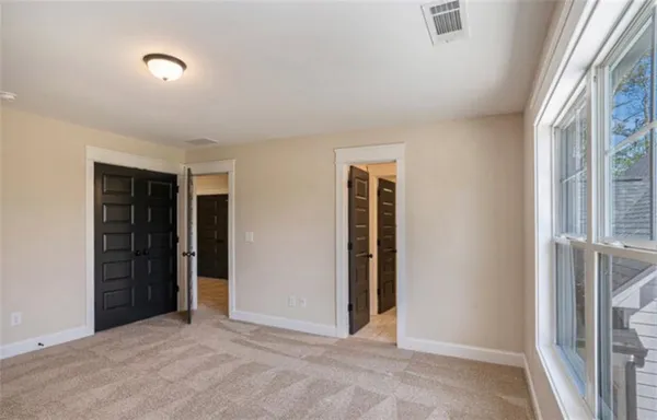 an empty room with closet and windows