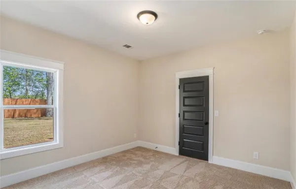 a view of an empty room with stairs and a window