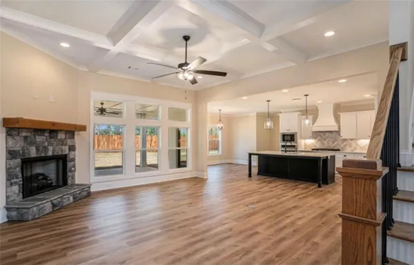 a large open kitchen with a refrigerator a stove and a wooden floor