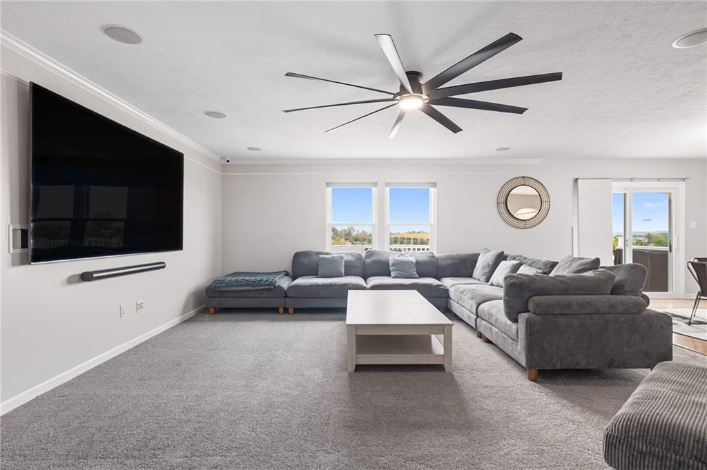 499 West Spring Grove Boulevard Rostraver Township, PA 15012 - Photo 11 of 46 a living room with couches a flat screen tv and kitchen view