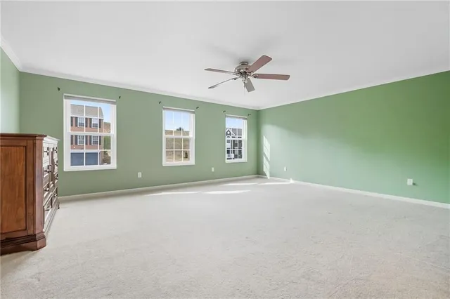 a view of an empty room with a window and a kitchen