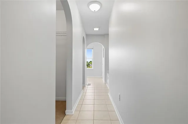 a view of a hallway with wooden floor and a bathroom