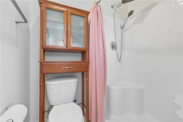 a bathroom with a toilet and a shower