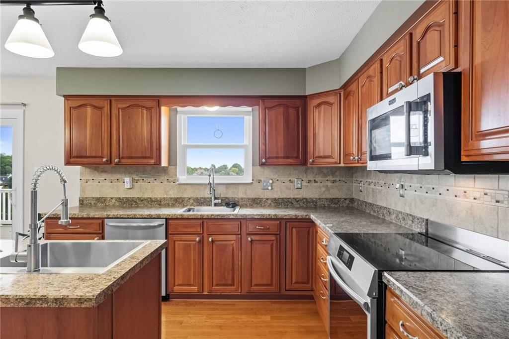 499 West Spring Grove Boulevard Rostraver Township, PA 15012 - Photo 8 of 46 a kitchen with granite countertop a sink a stove and cabinets