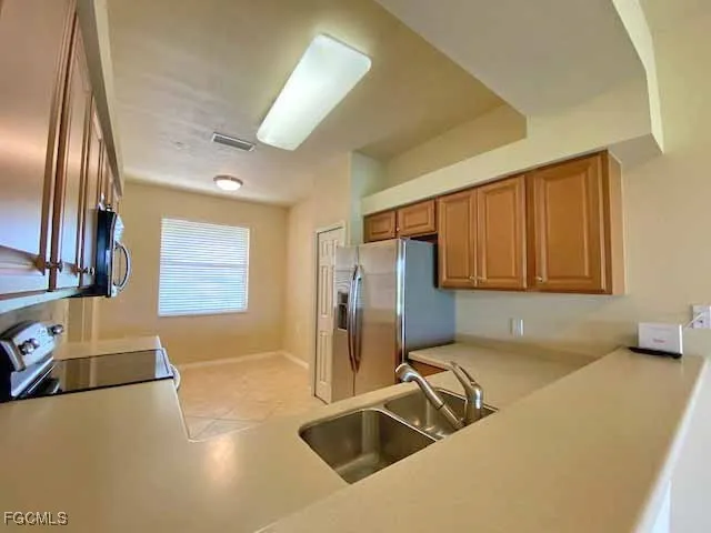a view of a kitchen with stainless steel appliances granite countertop a sink and a refrigerator