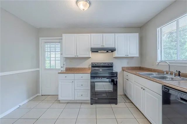 a kitchen with cabinets appliances a sink and a window