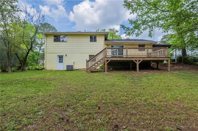 a view of an house with backyard and trees