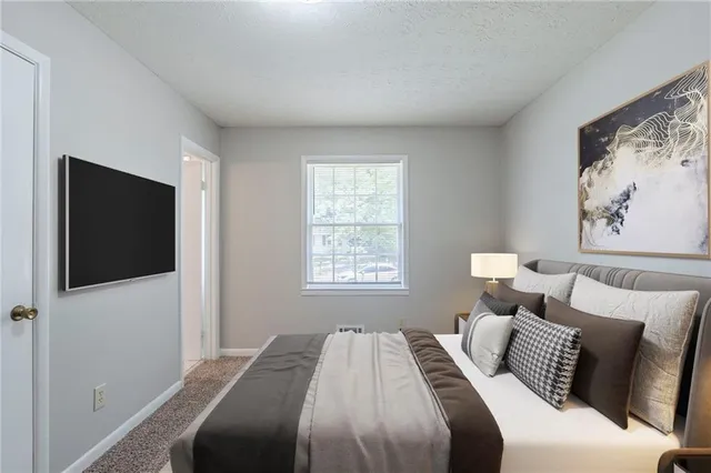 a bedroom with a large bed and a window