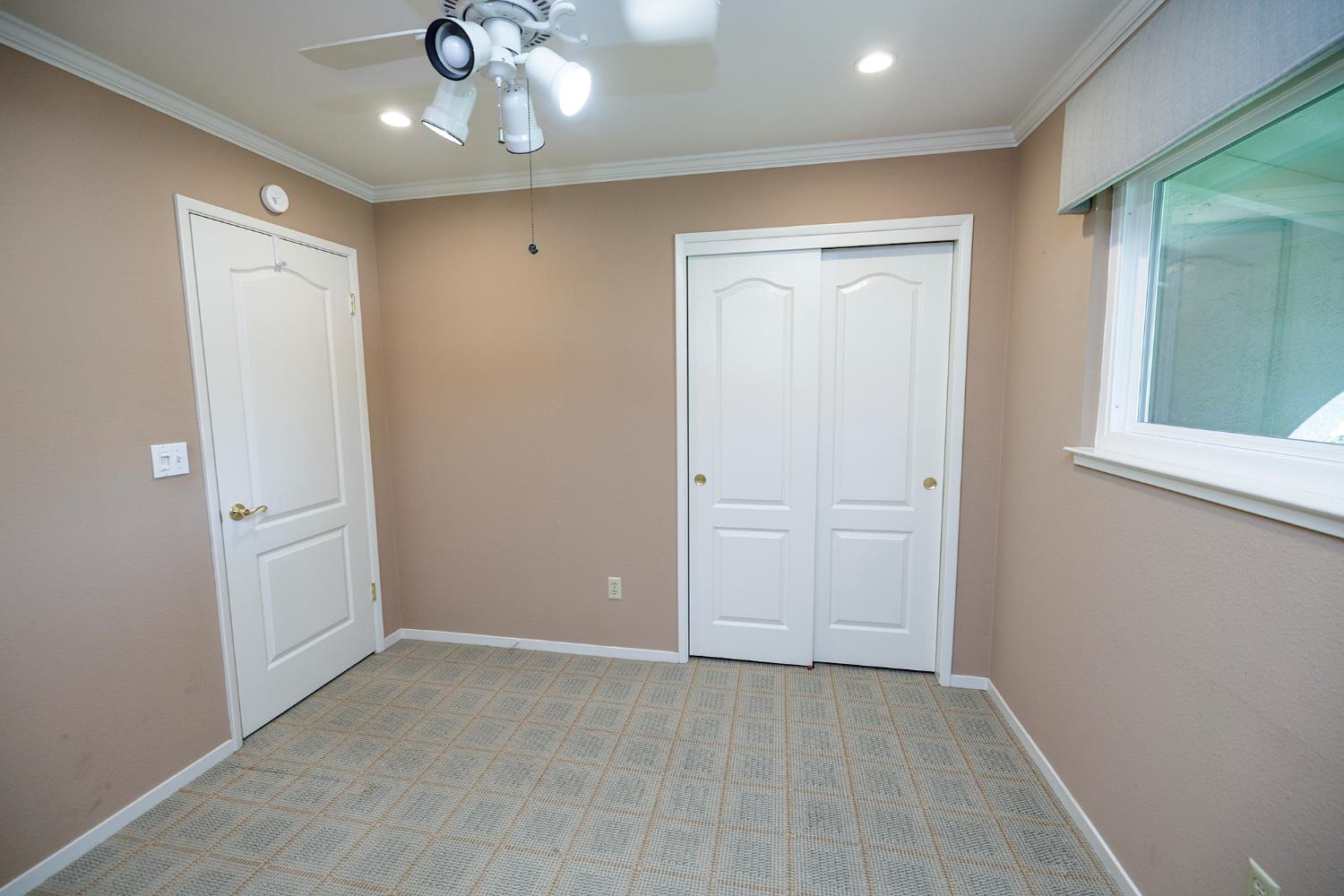 1001 Winsted Lane Modesto, CA 95355 - Photo 26 of 45 an empty room with a hallway and a chandelier fan