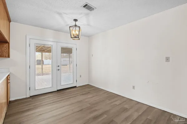 a view of a kitchen with wooden floor and a window