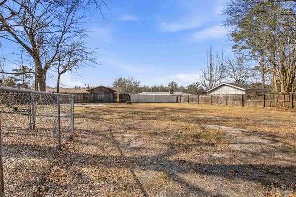 a view of a yard with a house and a large tree