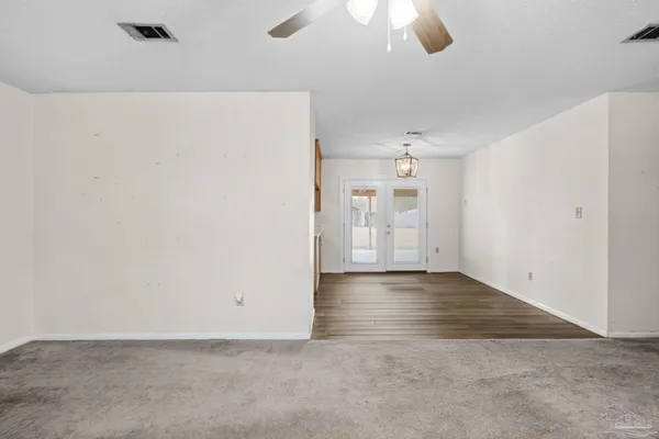 an empty room with closet and windows