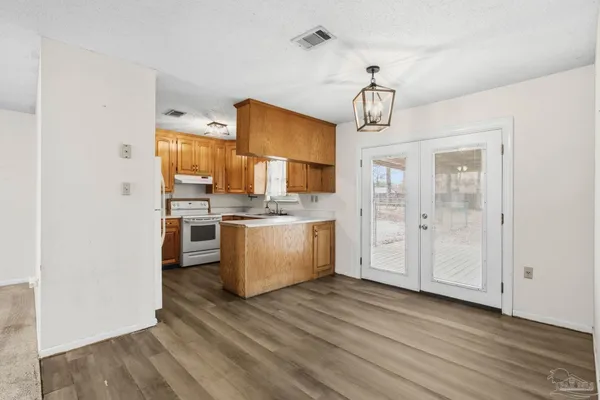 a view of kitchen with stainless steel appliances granite countertop cabinets and wooden floor