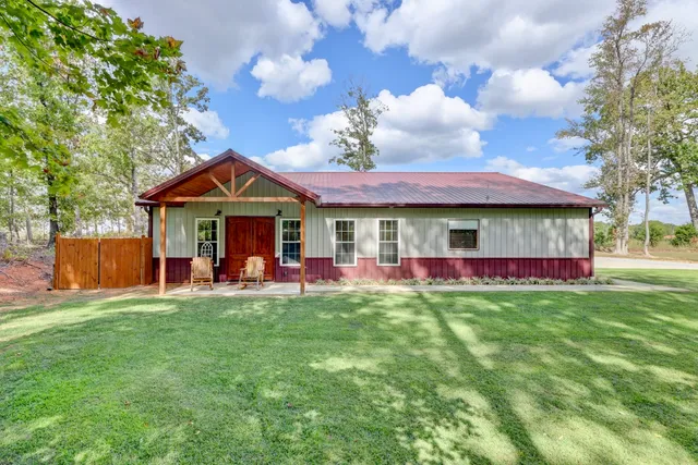 a view of a house with table and chairs under an umbrella