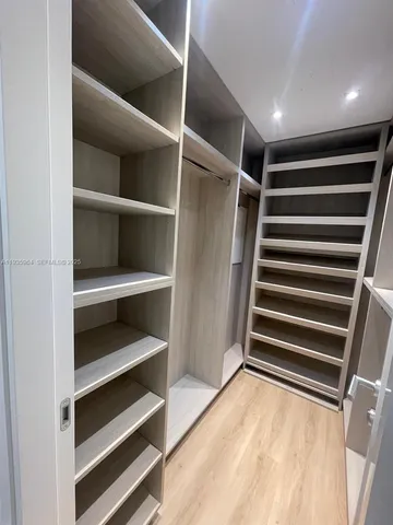 a view of walk in closet with empty racks