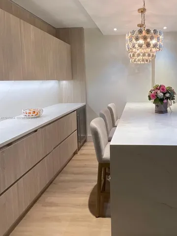 a room with a table chairs and chandelier