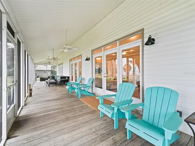 a dining room with wooden floor a chandelier a wooden table and chairs