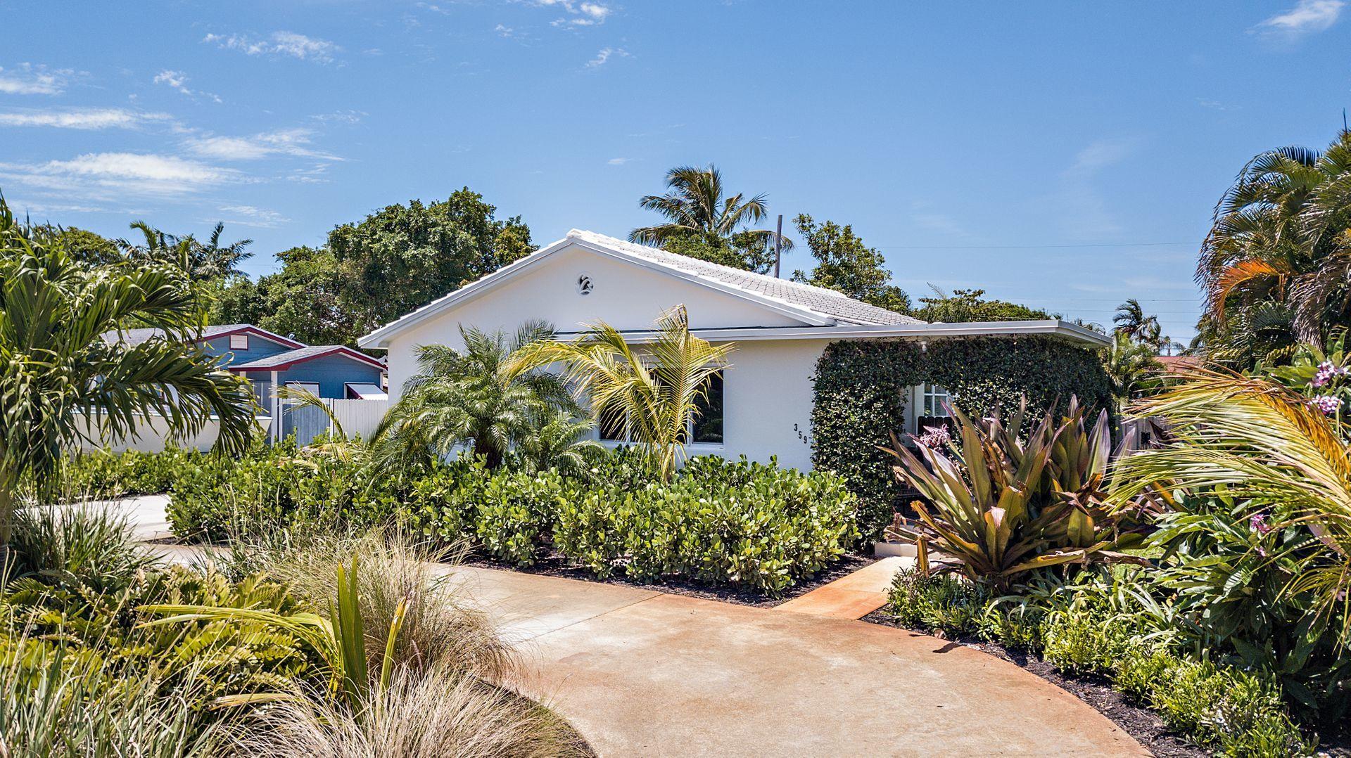 359 Ellamar Road West Palm Beach, FL 33405 - Photo 27 of 28 a front view of a house with a yard and potted plants
