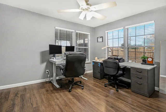 a view of a workspace with furniture and a window
