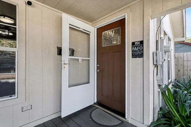 a view of hallway with walk in closet and wooden floor