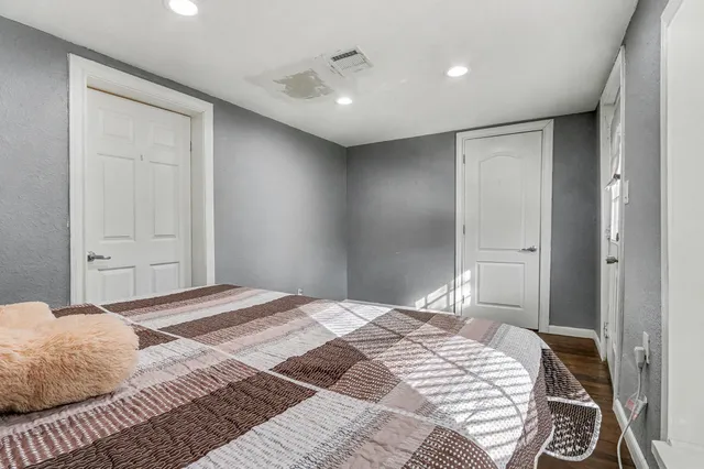 a bedroom with a large bed and a chandelier
