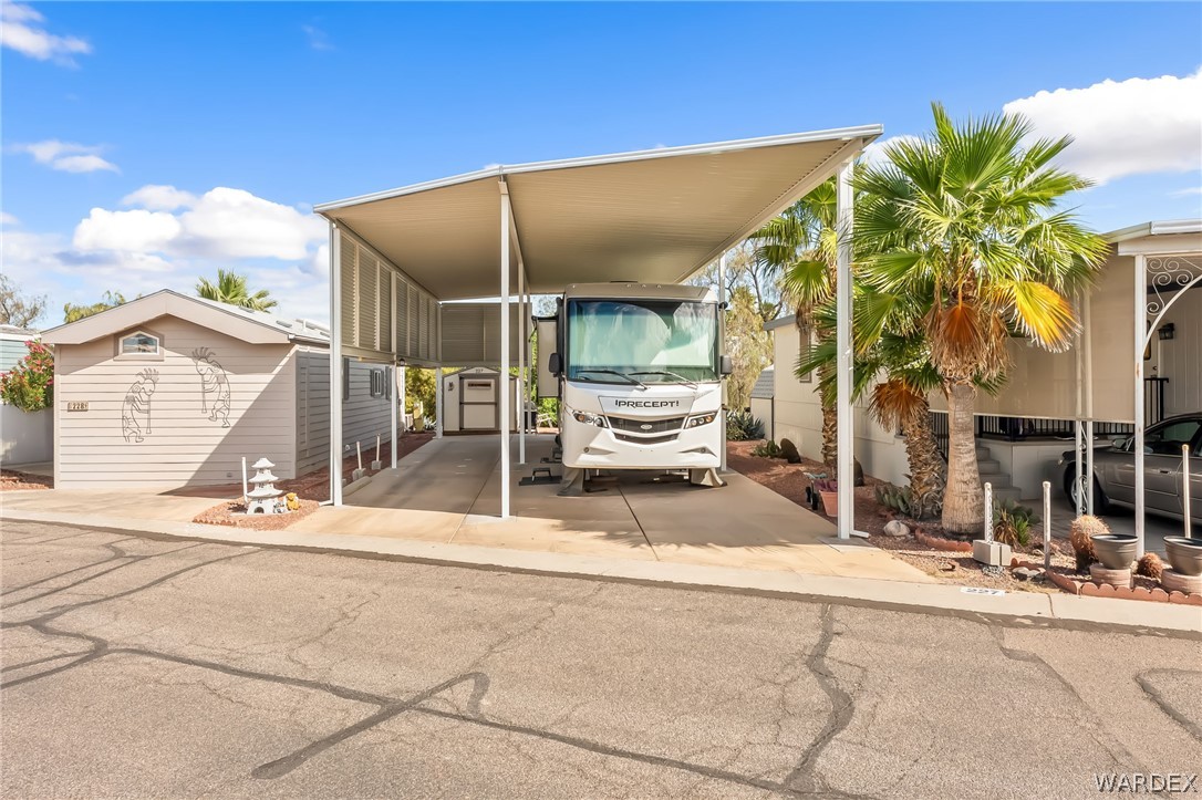 2000 Ramar Road, Unit 227 Bullhead City, AZ 86442 - Photo 5 of 40 Welcome home to a wide, covered RV parking space with full hook-up potential, flanked by palm trees and additional covered parking?designed for effortless desert living.