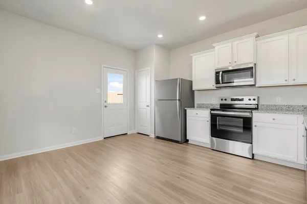 a kitchen with a refrigerator and a stove top oven